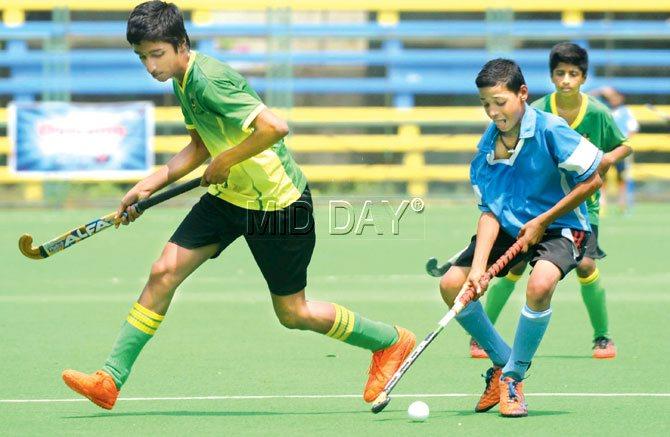 Abhay Tiwari in blue of Our Lady of Dolours Marine Lines and Ezekial Shetty in green of St Stanislaus Bandra battle it out in the semi-finals of the MSSA inter-school Ahmed Sailor hockey tournament at the MHAL-Mahindra Stadium, Churchgate yesterday. Pic/Suresh KK