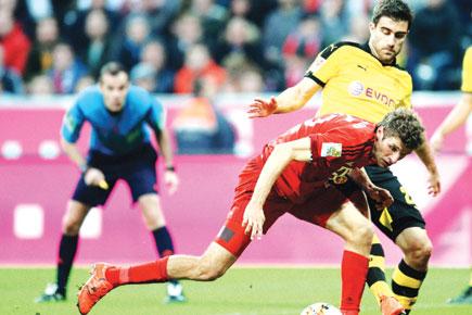 Bayern Munich's striker Thomas Mueller tries to get past Dortmund's Sokratis (right) during their Bundesliga tie in Munich on Sunday