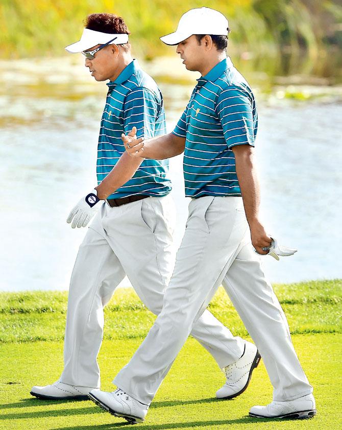 International team player Anirban Lahiri (right) walks with teammate Thongchai Jaidee at the 18th hole during a practice session at the Jack Nicklaus Golf Club in Incheon, South Korea yesterday. Pic/AFP
