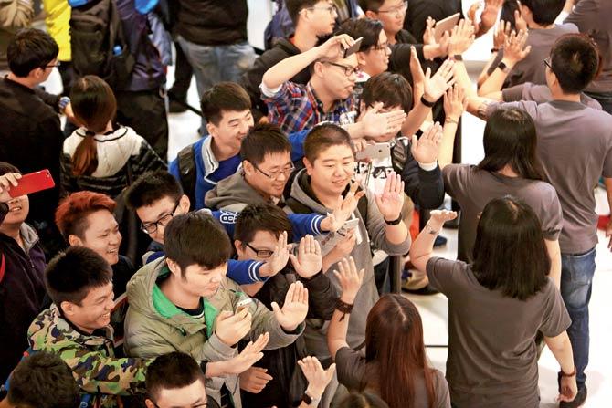 Apple store employees greet customers at the opening of a new store in Dalian, China’s Liaoning province. US technology giant Apple will keep investing in China despite slowing growth. China’s sixth cut in interest rates, was the trigger for market gains. AFP photo