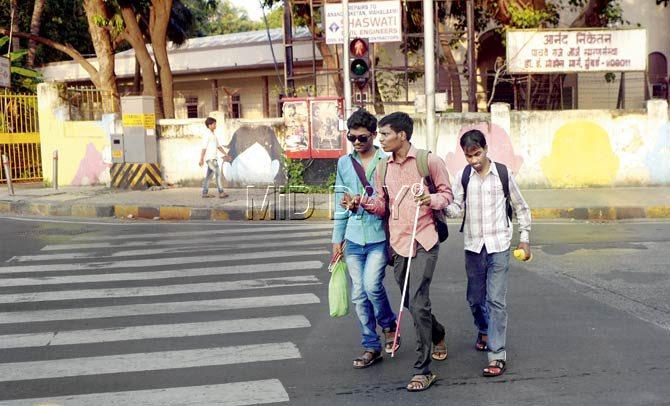 Visually impaired students of the NAB Rehabilitation Centre in Mumbai, take advantage of a rare empty stretch of road at Mahalaxmi to cross. Pic/Pradeep Dhivar
