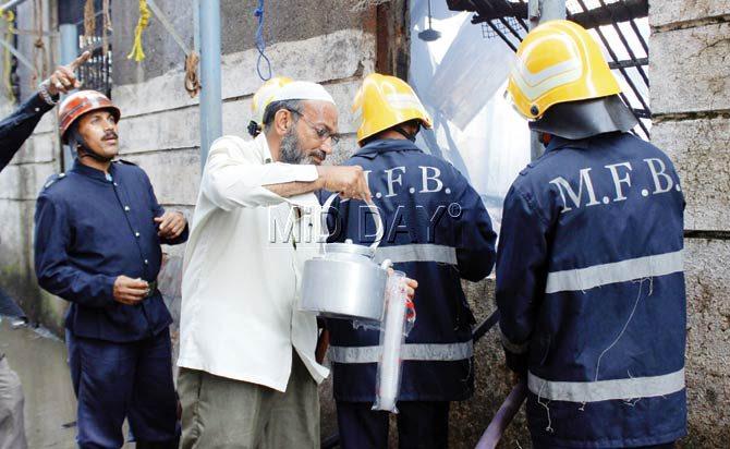 A resident of the building offers tea to the exhausted firefighters. Pics/Tushar Satam