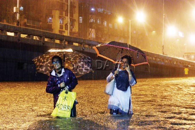 Women wade through knee-deep water in Parel. Pic/Tushar Satam