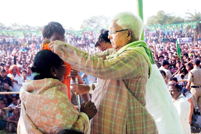 RJD chief Lalu Prasad welcomes a visitor at an election rally at Jeevdhara, East Champaran, in Bihar. Pic/PTI