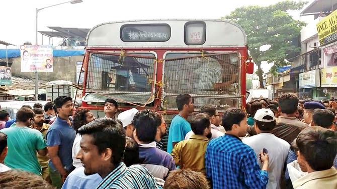 Cops guard the Malwani bus depot after angry locals pelted stones at it