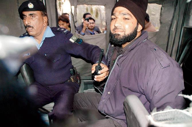 Pakistani police guard Mumtaz Qadri (right) in a police van after he assassinated Governor Salman Taseer on January 4, 2011. Qadri killed a man he was duty-bound to protect, but shamelessly maintains he did the right thing. Pic/AFP