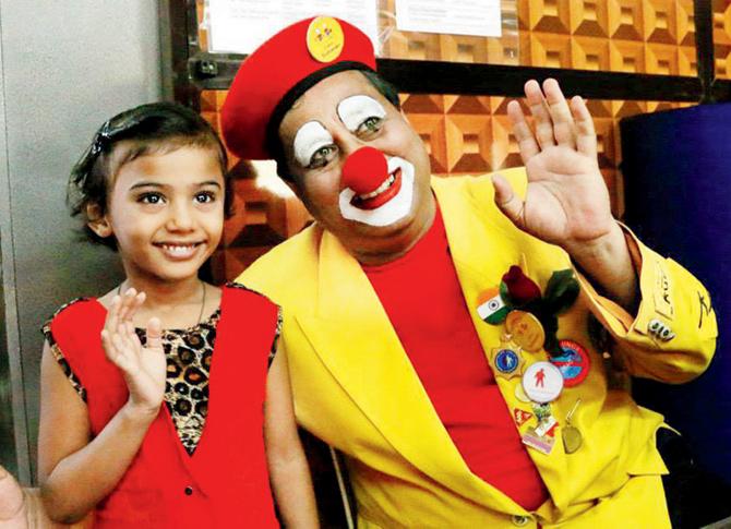 SPREADING SMILES: Pravin Tulpule (r) entertains a child while in clown avatar 