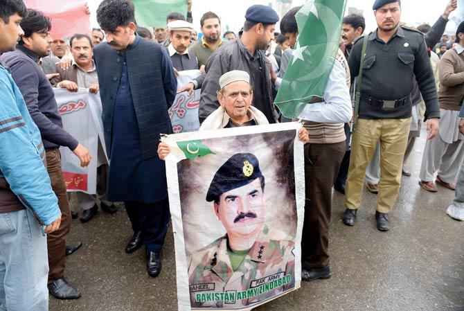 A Pakistani civil society worker carries a photograph of General Raheel Sharif during a peace rally in Islamabad in February, after the country stepped up its fight against militants following a massacre at a Peshawar school last year. Pic/AFP