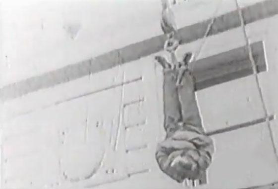 Harry Houdini suspended on a crane wearing a straightjacket. Pic/YouTube