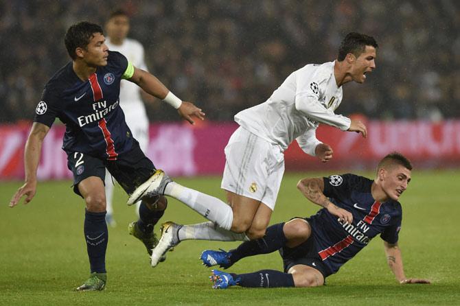 Cristiano Ronaldo (C) fights for the ball with Paris Saint-Germain