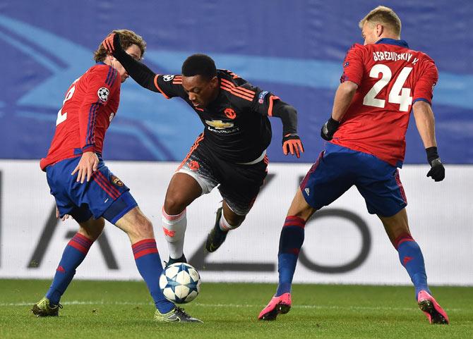 Mario Fernandes (L) and Vasily Berezutskiy (R) vie for the ball with United