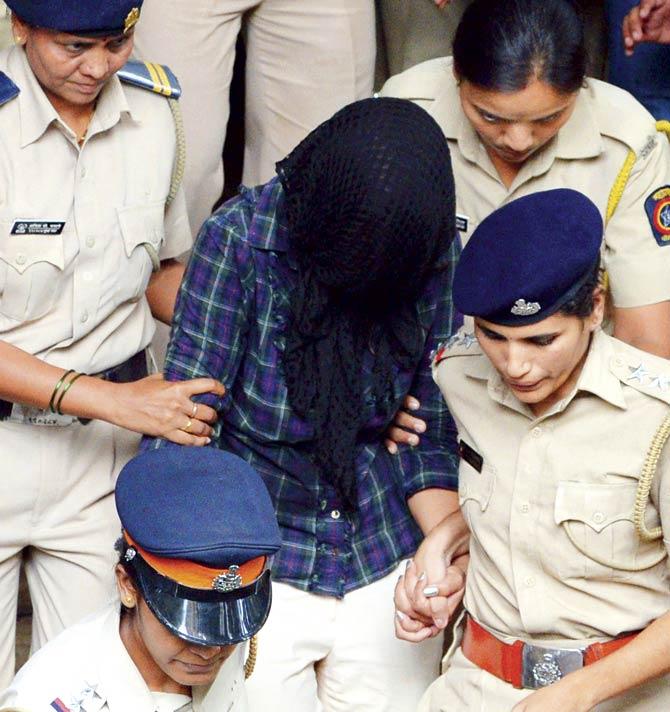 Cops lead Indrani Mukerjea out of a city court yesterday. Pic/AFP