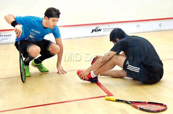 Borja Golan (left) checks up on Saurav Ghosal after he slipped and fell in the third game at the CCI