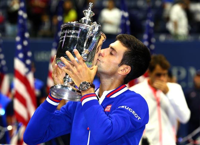 Novak Djokovic of Serbia celebrates with the trophy after defeating Roger Federer of Switzerland during their Men
