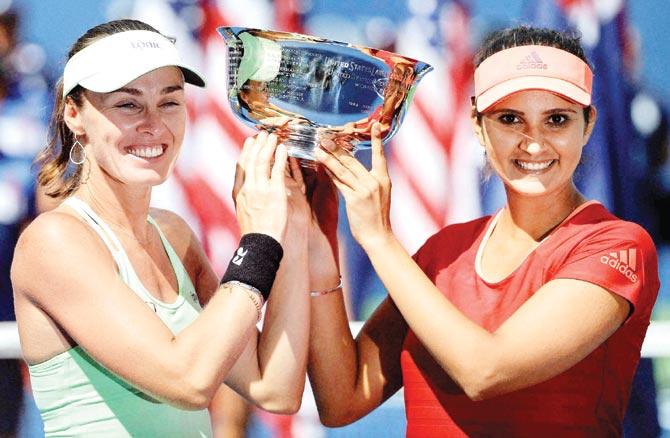 Sania Mirza (right) and Martina Hingis lift the US Open doubles trophy yesterday. Pic: AP/PTI