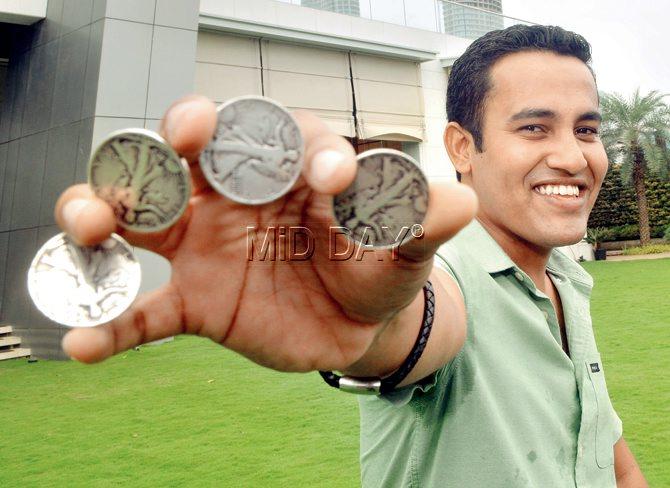 Magician Ian Fernandes strikes a pose with  the coins that he uses for money tricks. Pics/Sayed Sameer Abedi