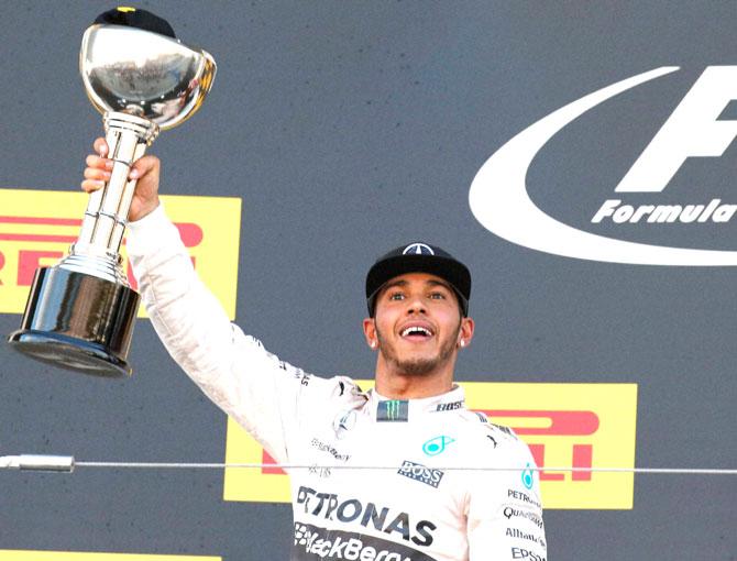 Mercedes driver Lewis Hamilton of Britain celebrates with the trophy on the podium after winning the Japanese Formula One Grand Prix at the Suzuka Circuit in Suzuka. Pic/AP, PTI