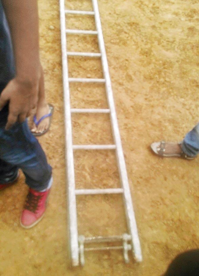 In the absence of a stretcher, tournament organisers bring a ladder to place under Jaiswal to carry him out of the ground