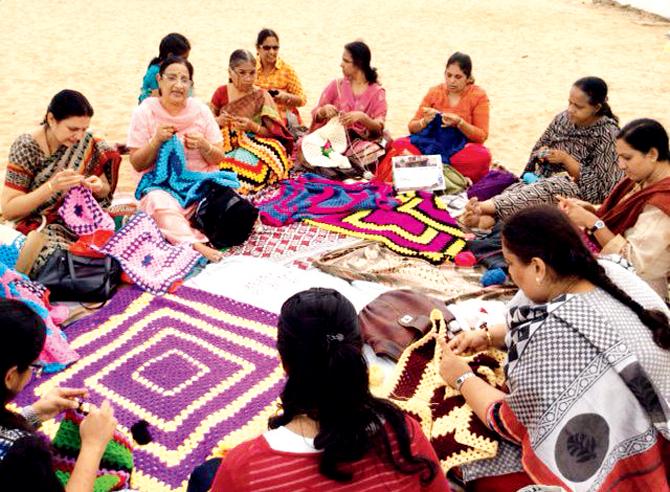 A group knitting session in progress at Besant Nagar Beach in Chennai