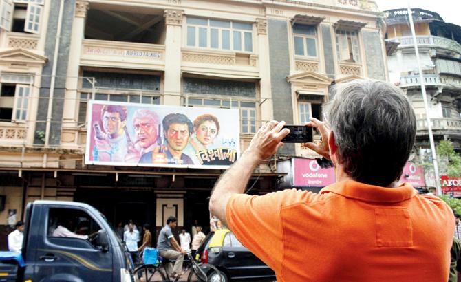 A participant of the walk takes a photo of Alfred Talkies in Grant Road. Pic courtesy/ Tushar Satam