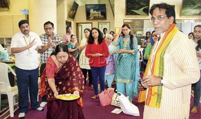 Dr Kala Acharya (l) performs the aarti as participants join Pandit Shukla in the Ganesh mantras
