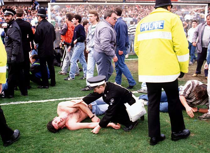 Policemen rescue soccer fans at Hillsborough stadium April 15, 1989 when 96 fans were crushed to death and hundreds injured after support railings collapsed during a match between Liverpool and Nottingham Forest