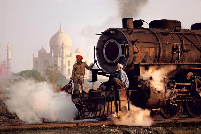 This photograph recorded in 1983 shows the contrast between a mighty technology — the steam locomotive — and the transcendent aesthetic of the Taj Mahal, with its light-reflecting surface