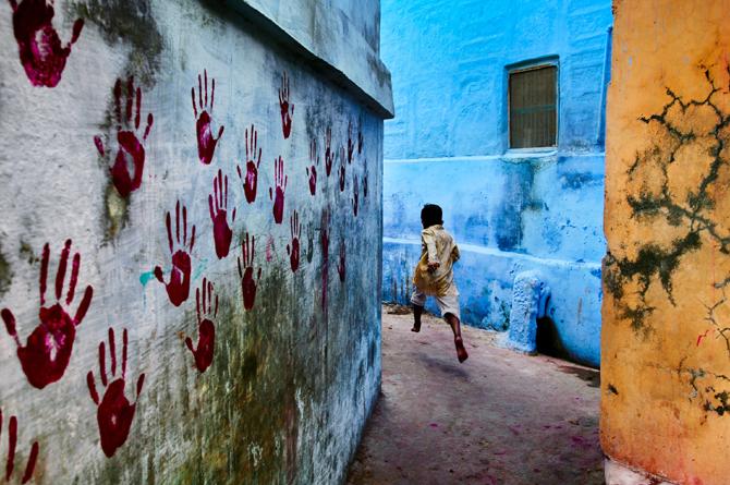 A boy in mid-flight in one of the narrow alleyways in the Blue City, at the foot of Mehrangarh fort, north of Jodhpur, Rajasthan, 2007