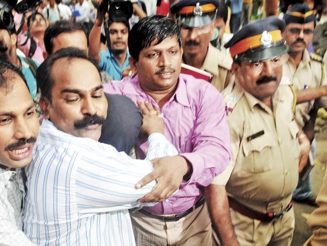 This file photo from July 2010 shows Javed Shaikh being taken from a press conference at the Mumbai Police Commissioner’s office