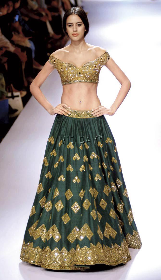 A model in a gold embellished green lehenga from Arpita Mehta’s line