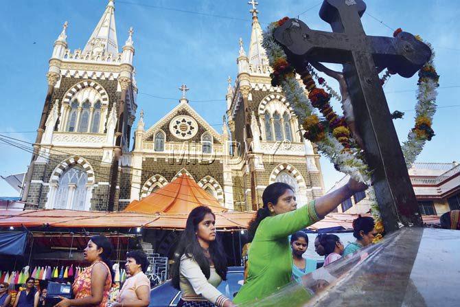 A devotee prays at a crucifix facing Mount Mary’s Basilica in Bandra on Wednesday, which was celebrated as the birthday of Mother Mary. Pic/Sayed Sameer Abedi