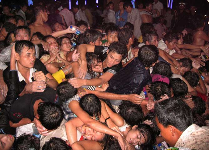 People reach for help among some unconscious ones near a bridge in Phnom Penh on November 23, 2010 after at least 347 people died in a stampede while millions were celebrating the end of the annual Water Festival.