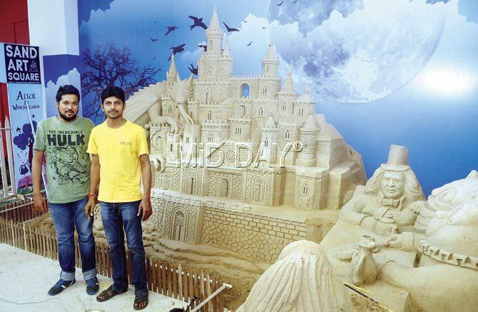 Jerry Jose, the ideator (l) and Narayan Sahu (r) stand with the Alice in Wonderland sand sculptures at R City Mall, Ghatkopar