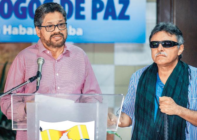 Commander of the FARC-EP leftist guerrillas, Ivan Marquez (left), reads a statement during peace talks with the Colombian government next to FARC commander Jesus Santrich in Havana on September 11. Pic/AFP
