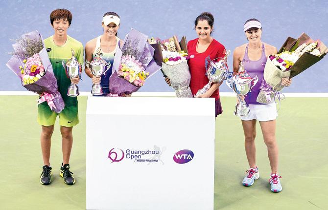 China’s Xu Shilin and You Xiaodi (left) with their runner-up trophies, alongside Guangzhou Open women’s doubles champs Sania Mirza and Martina Hingis (right) on Saturday. pics/afp
