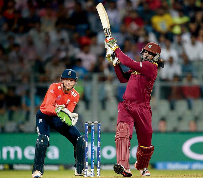 West Indies’ dangerman Chris Gayle hits a six against England at Wankhede Stadium, Mumbai on March 16, watched by wicketkeeper Jos Buttler. The Caribbeans ended up winning by six wickets. Pic/Getty Images