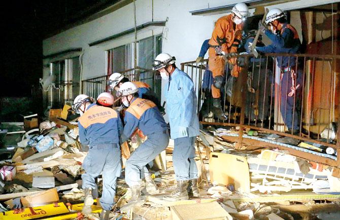 Rescue workers save a victim from a collapsed building in Kuammoto. Pics/AFP
