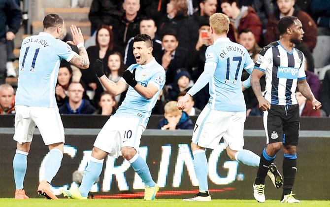 An ecstatic Manchester City Sergio Aguero (centre) is congratulated by teammates after scoring the opening goal during the English Premier League match against Newcastle United at St James