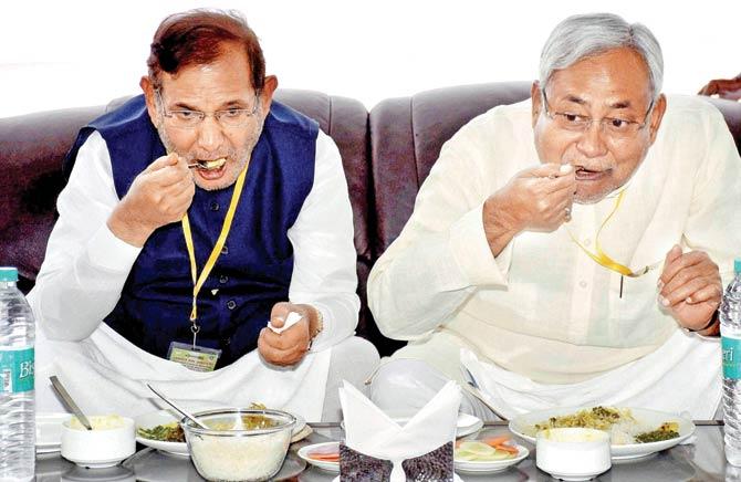Bihar Chief Minister and newly-elected JD-U President Nitish Kumar with party leader Sharad Yadav share a meal after the National Council Meeting in Patna on Saturday. Pic/PTI
