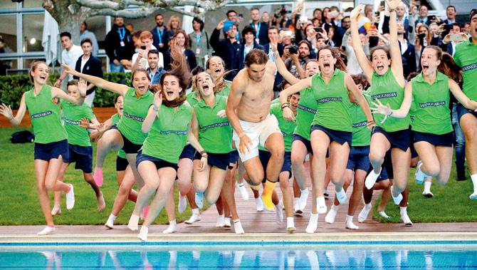 Rafael Nadal jumps into the swimming pool as Barcelona Open volunteers join in the celebrations of his Sunday’s win. Pic: AP/PTI