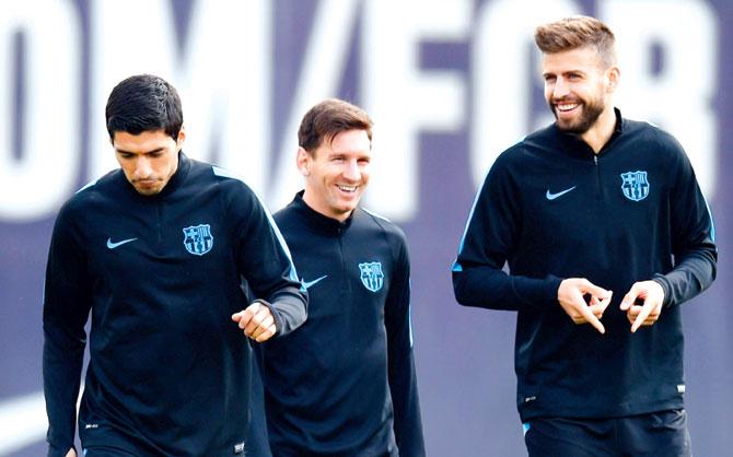 Barca players Luis Suarez (left), Lionel Messi (center) and Gerard Pique chat during a practice session in Barcelona yesterday. Pic/Getty Images