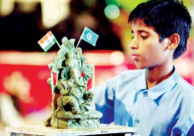 A Mumbai student creates a sculpture of Ganesha with flags of both, India and Pakistan as a message of peace. Pic/AFP
