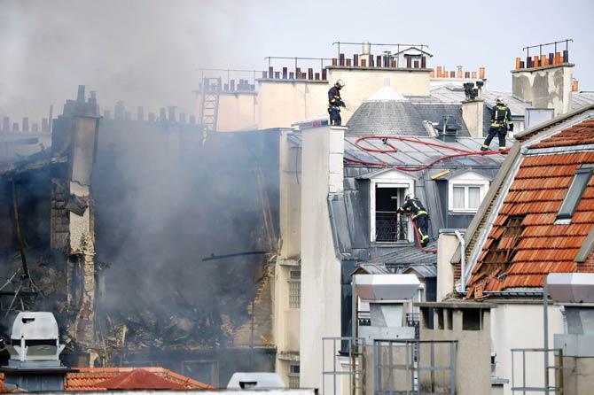 Firefighters intervene after a building exploded in Paris. Pic/AFP
