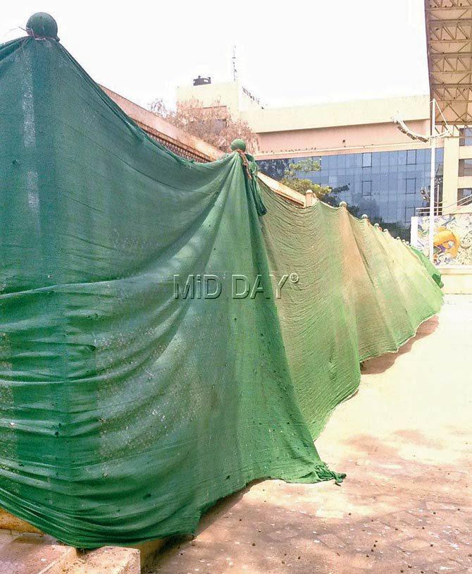 A green tarpaulin obscuring part of the view of the pool