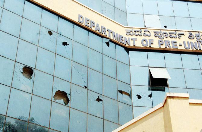 Glass panes of the department of pre-university education building damaged in stone pelting as students and parents staged a protest in front of the building. Pic/PTI