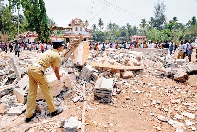 A security personnel analyses the debris of a building destroyed in the mishap
