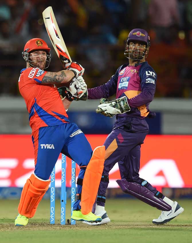 Gujarat Lions Brendon McCullum (L) watched by Rising Pune Supergiants captain Mahendra Singh Dhoni plays a shot during the 2016 Indian Premier League(IPL) match at the Saurashtra Cricket Association Stadium in Rajkot on Thursday.