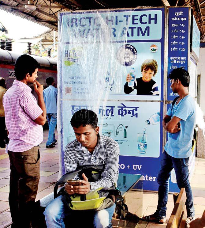Curious passengers inspect the water ATM at Khar. Pic/Atul Kamble