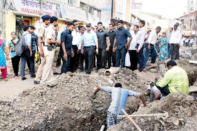 Thane Municipal Corporation Commissioner Sanjeev Jaiswal flanked by private security guards during an inspection of the road-widening project