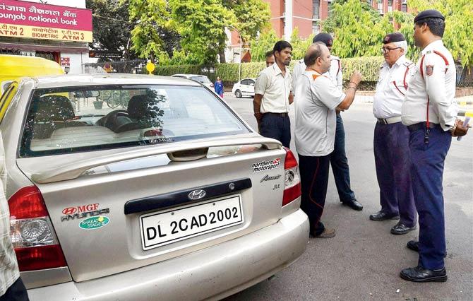 An offender argues with traffic cops after being pulled up for flouting the odd-even norm. Pic/PTI